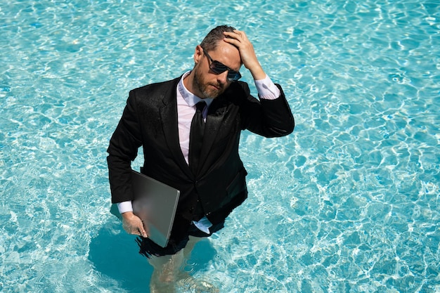 Hombre de negocios que trabaja a distancia en el agua de la piscina hombre de negocios que trabaja a distancia con una computadora portátil