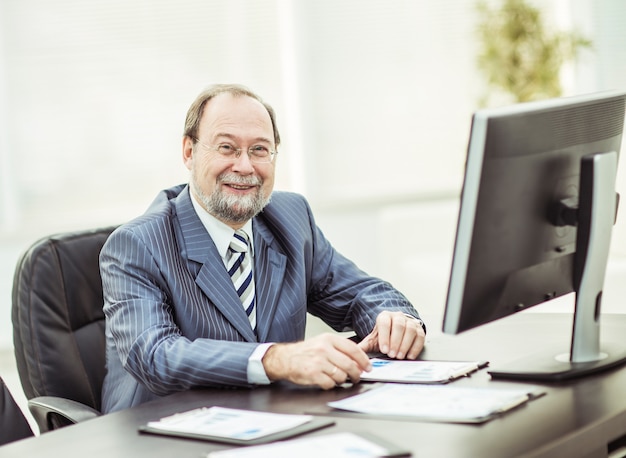 Hombre de negocios que trabaja con gráficos financieros en el lugar de trabajo.