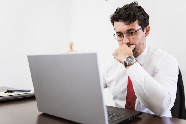 Hombre de negocios que trabaja en la oficina con ordenador portátil y documentos en su escritorio, concepto de abogado consultor.