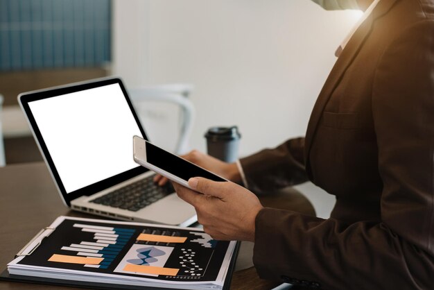 Hombre de negocios que trabaja en la oficina con tableta y computadora portátil en su escritorio asesor financiero analizando datos