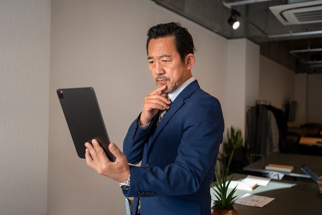 Foto hombre de negocios que trabaja en la vista lateral del ipad