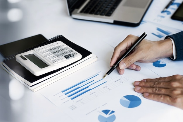 hombre de negocios que trabajan en la oficina con calculadora y portátil