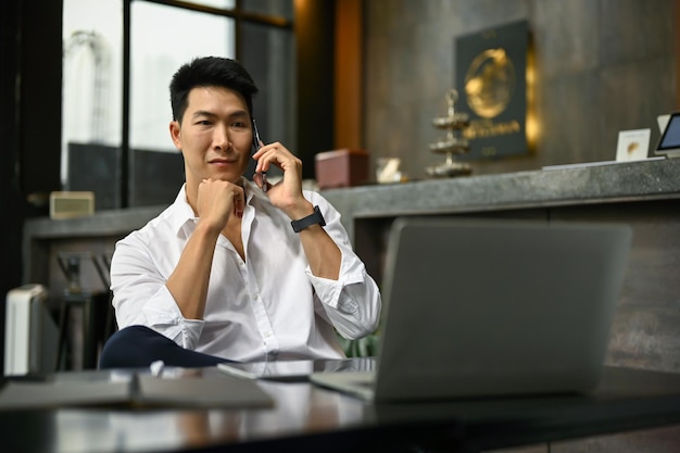 Un hombre de negocios que trata negocios a través de la llamada hablando por teléfono