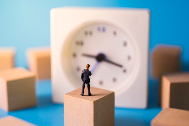 Foto hombre de negocios reflexivo con reloj en segundo plano