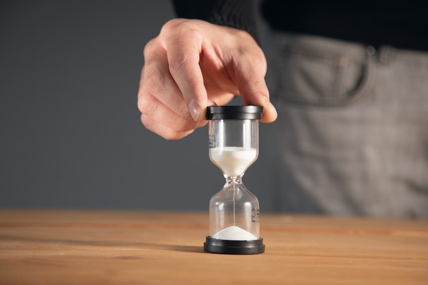 Hombre de negocios con reloj de arena en la oficina.