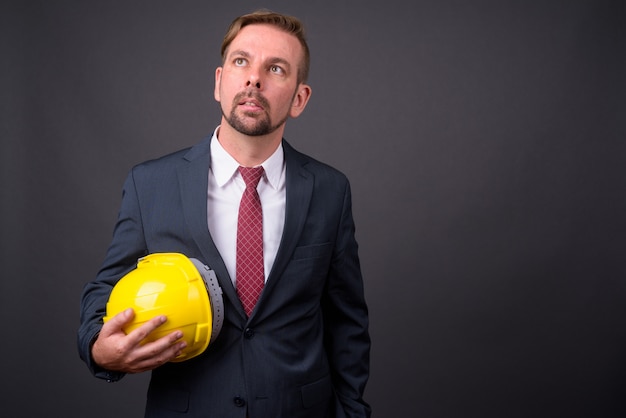 Hombre de negocios rubio barbudo con perilla con casco