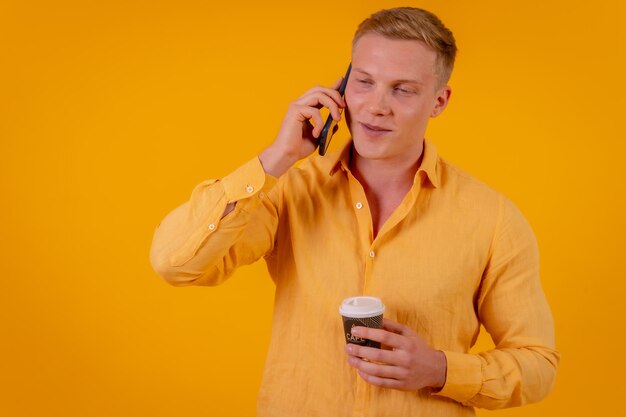 Hombre de negocios rubio caucásico de fondo amarillo haciendo una llamada con el teléfono