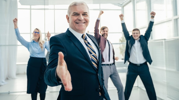 Hombre de negocios seguro tendiéndole la mano para un apretón de manos.