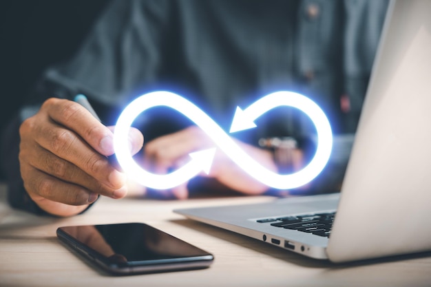 El hombre de negocios señala el símbolo del infinito que representa la conexión ilimitada en la tecnología de datos