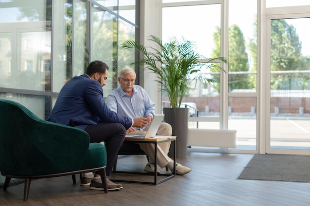 Un hombre de negocios senior atento que está en todos los oídos mientras escucha la presentación del proyecto