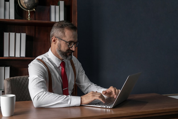 Hombre de negocios senior enfocado trabajando en la computadora portátil