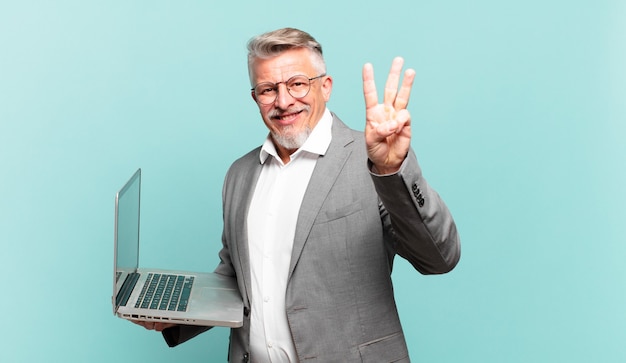 Hombre de negocios senior sonriendo y mirando amigable, mostrando el número tres o tercero con la mano hacia adelante, contando hacia atrás