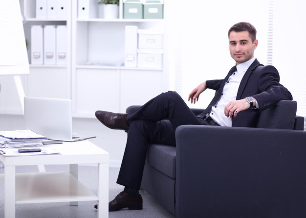 hombre de negocios, sentado, en, sofá, en la oficina