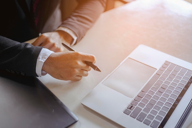 El hombre de negocios sentado a trabajar en el escritorio de la oficina tiene una taza de café al lado de problemas y conceptos de trabajo eficientes. empresario, trabajo, negocios, tecnología, gestión, conceptos de planificación.