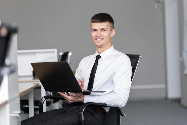 hombre de negocios, sentado, en el trabajo, mirar la computadora portátil, oficina, trabajo, concepto