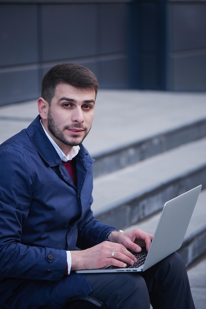 Hombre de negocios, sentar escaleras, con, computador portatil