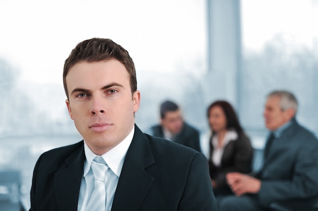 Foto hombre de negocios serio en compañía de colegas