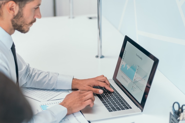 Foto hombre de negocios serio está trabajando en su computadora portátil en la oficina