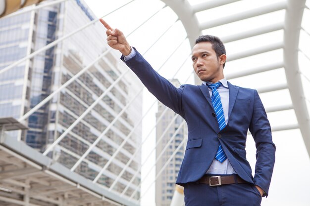 Hombre de negocios en serio y levantando el puño con el número 1 en el aire, el éxito empresarial