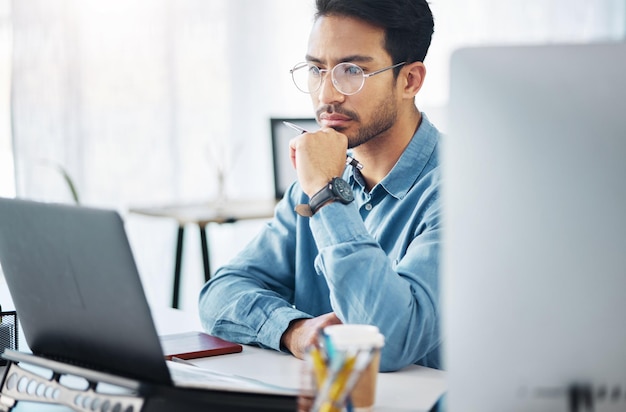 Hombre de negocios serio y pensando en una computadora portátil en una empresa o agencia de inicio de oficina Computadora de empleado masculino enfocada y solución de ideas de inspiración u objetivos de planificación de revisión de decisiones o estrategia