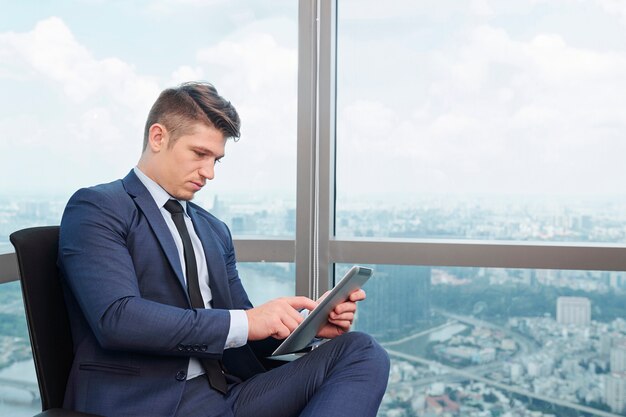 Hombre de negocios serio trabajando en tableta