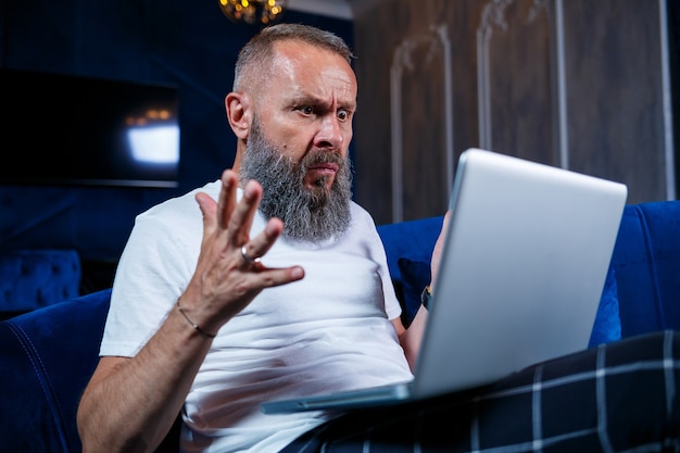 Hombre de negocios se sienta con una taza de café y hace un nuevo proyecto con muecas en su rostro.