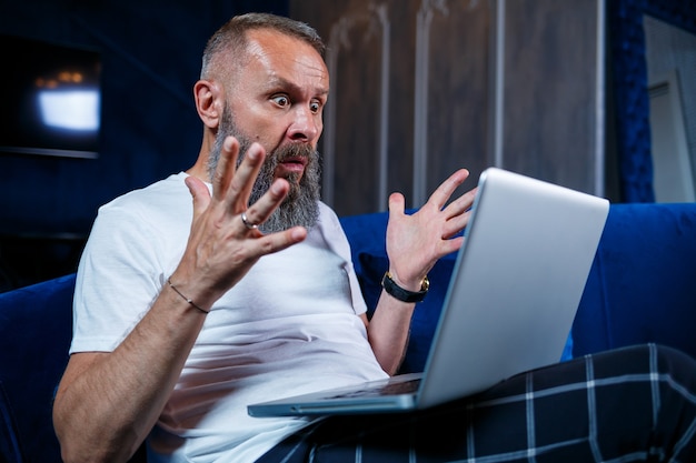 Foto hombre de negocios se sienta con una taza de café y hace un nuevo proyecto con muecas en su rostro.