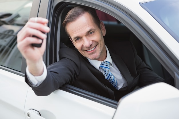 Hombre de negocios sonriendo y mostrando clave