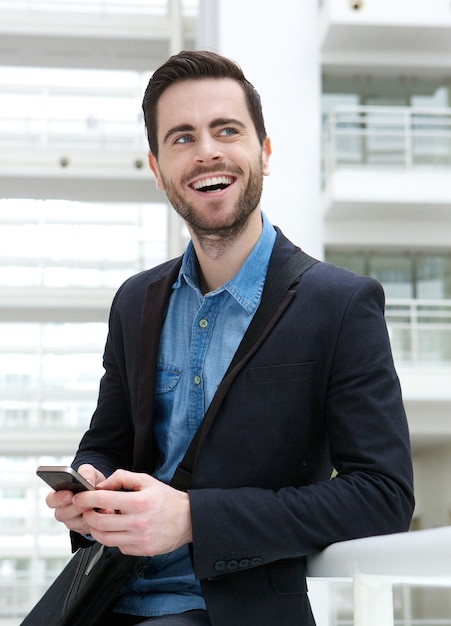 Hombre de negocios sonriendo con teléfono móvil