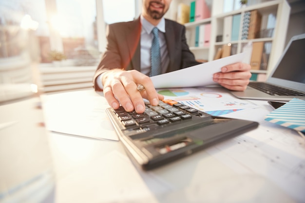 Foto hombre de negocios sonriente, calcular, finanzas, cicatrizarse