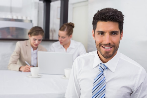 Foto hombre de negocios sonriente con los colegas en el escritorio de oficina