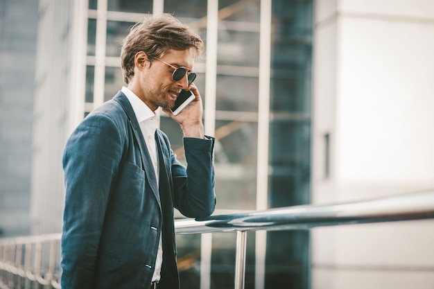 Hombre de negocios sonriente feliz hablando por teléfono.