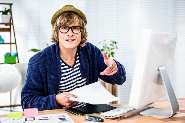 Hombre de negocios sonriente del inconformista que trabaja en su escritorio