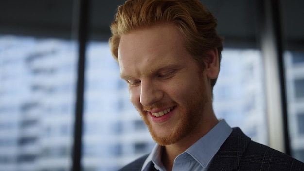 Hombre de negocios sonriente mirando tableta Retrato profesional corporativo trabajando cerca de la ventana de la oficina Expresión de la cara del hombre feliz Hombre pelirrojo de primer plano posando en la cámara