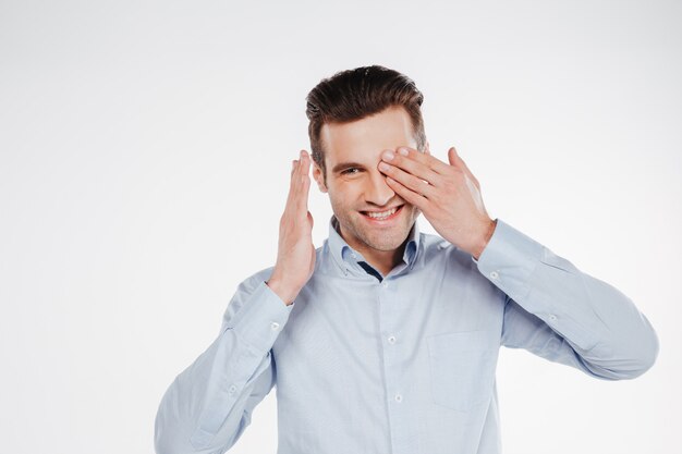 Hombre de negocios sonriente que cubre un ojo