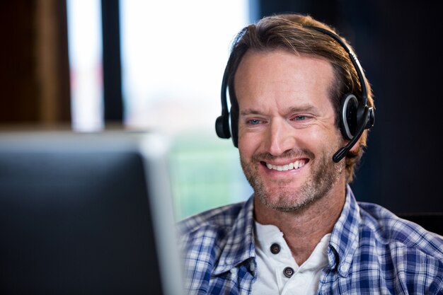 Hombre de negocios sonriente que trabaja en la computadora