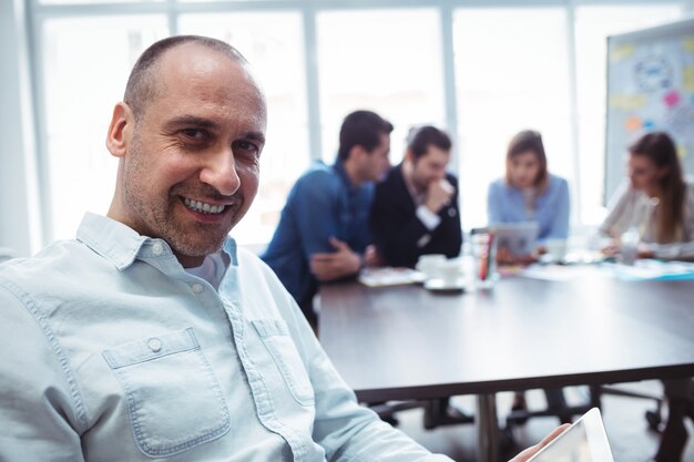 Hombre de negocios sonriente que usa la tableta digital