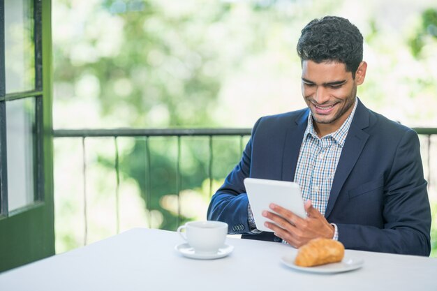 Hombre de negocios sonriente que usa la tableta digital