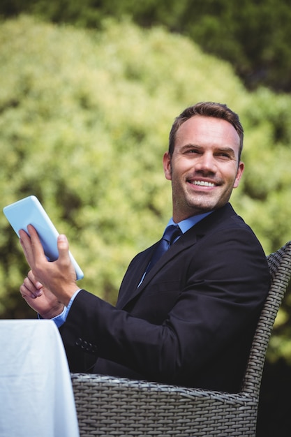 Foto hombre de negocios sonriente que usa la tableta