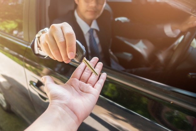 El hombre de negocios está sosteniendo el coche dominante en el coche