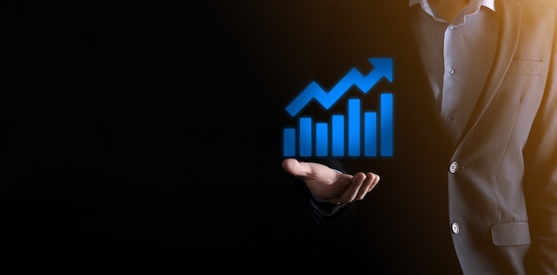 Hombre de negocios sosteniendo un gráfico con crecimiento de beneficios positivos