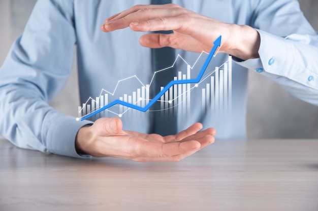 Hombre de negocios sosteniendo un gráfico con crecimiento positivo de beneficios. planificar el crecimiento de la gráfica y aumento de la gráfica de indicadores positivos en su negocio. Más rentable y en crecimiento.