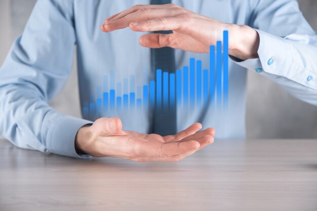 Hombre de negocios sosteniendo un gráfico con crecimiento positivo de beneficios. planificar el crecimiento del gráfico y el aumento de los indicadores positivos del gráfico