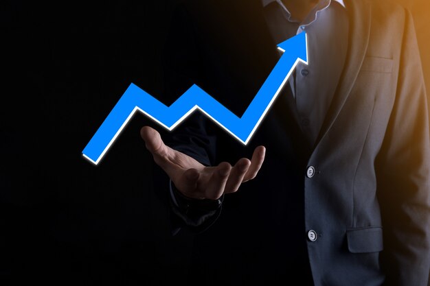 Hombre de negocios sosteniendo un gráfico con crecimiento positivo de beneficios. planifique el crecimiento de la gráfica y el aumento de la gráfica de indicadores positivos en su negocio. Más rentable y en crecimiento.