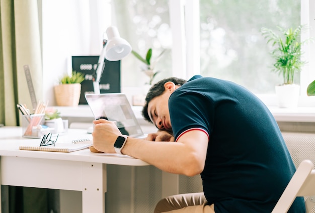 Hombre de negocios sosteniendo su cabeza trabaja en una computadora portátil