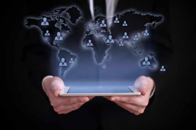 hombre de negocios sosteniendo una tableta PC con el mapa de proyección del mundo en la pantalla iconos y personas de todo el mundo búsqueda de trabajo de reclutamiento global concepto de negocio de reclutamiento internacional