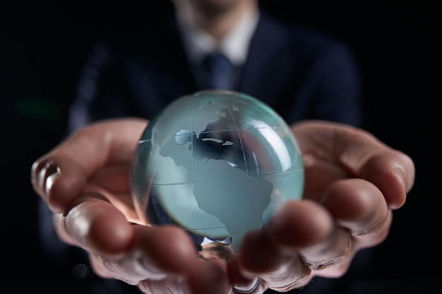 Foto el hombre de negocios sostiene el mundo global el planeta tierra en la mano del hombre de negocios muestra el calentamiento global