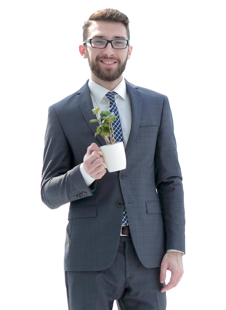 El hombre de negocios sostiene una planta joven verde