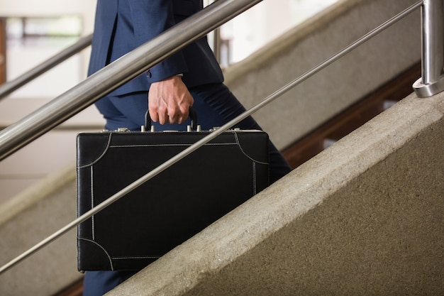 Foto hombre de negocios subiendo las escaleras