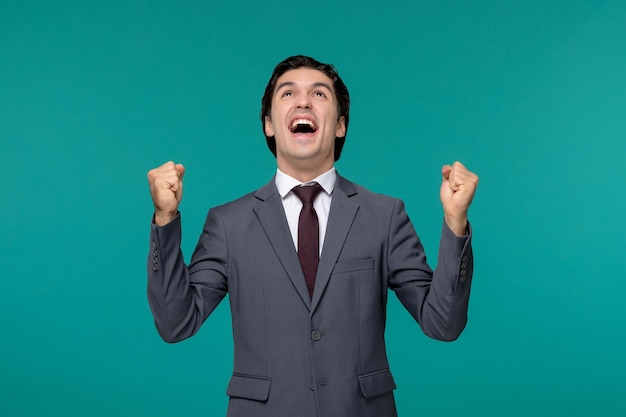 Hombre de negocios súper feliz guapo chico lindo en traje de oficina gris levantando los puños